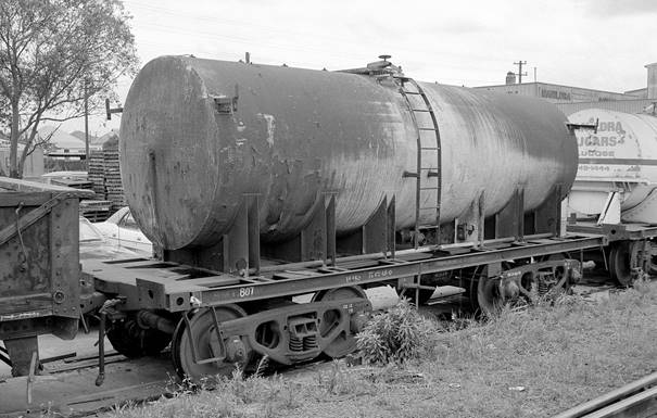 A train that is sitting in the grass

Description automatically generated