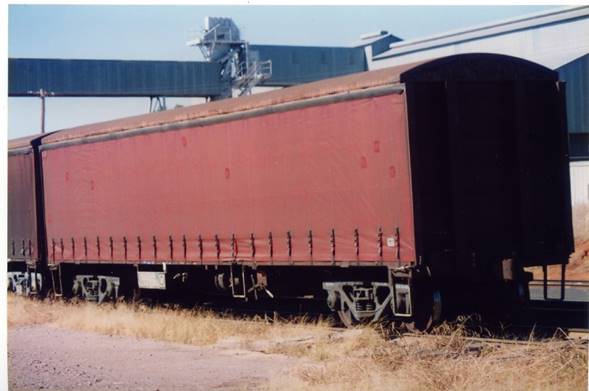 A train is parked on the side of a dirt field

Description automatically generated